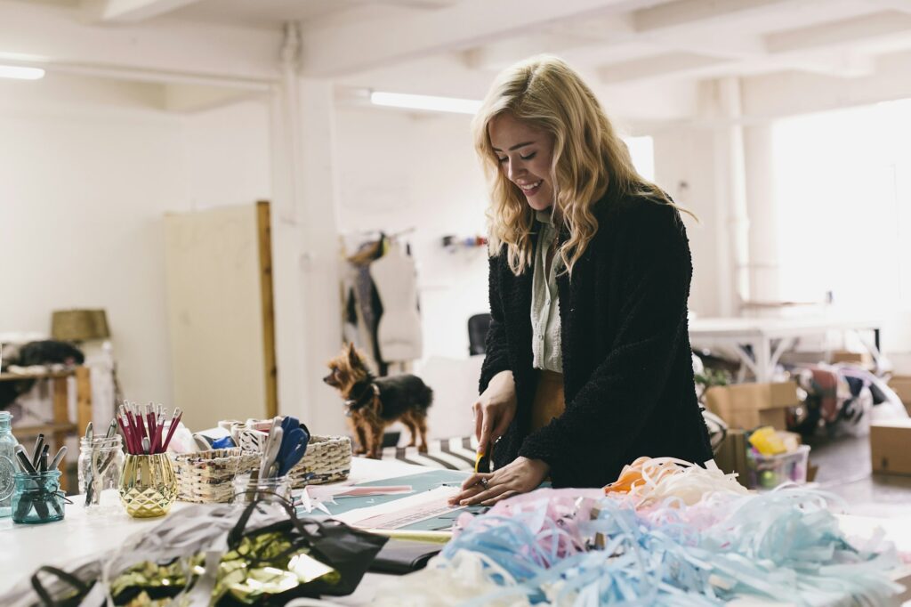 Female textile designer cutting textiles in design studio